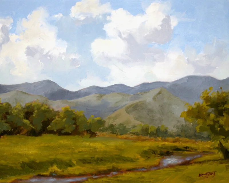 plein air landscape with grassy meadow small stream and blue mountain range