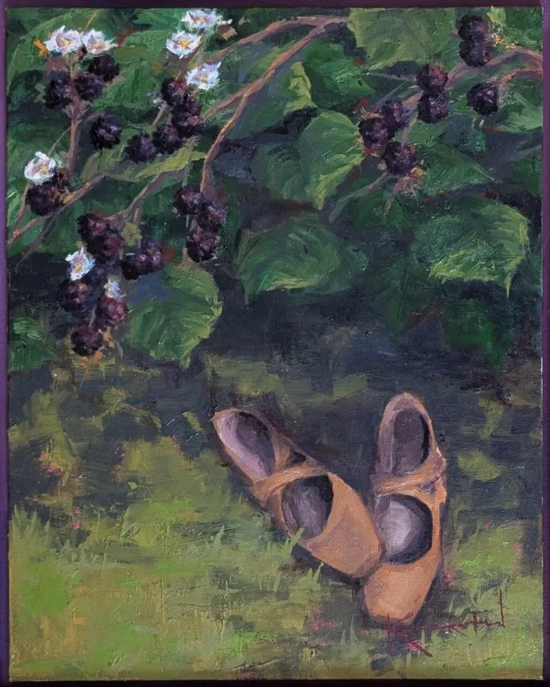Worn brown leather shoes on grass beneath branch of ripe blackberries and white blossoms