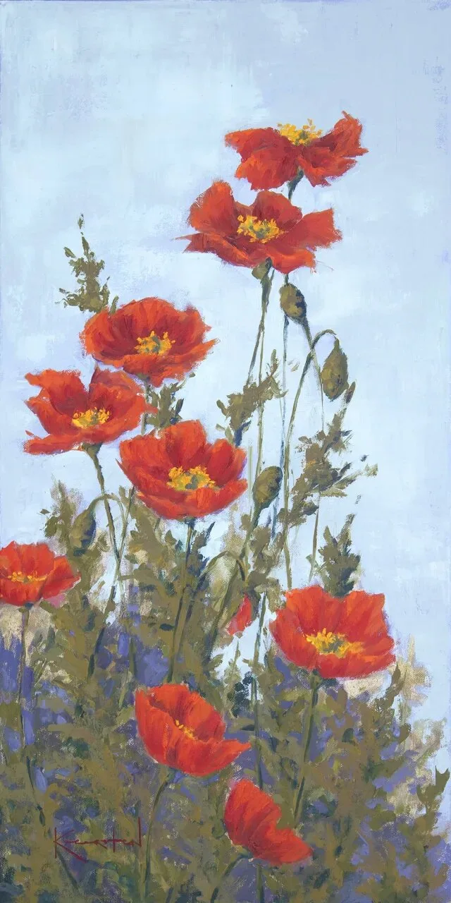 Tall red poppies with yellow centers against pale blue sky background