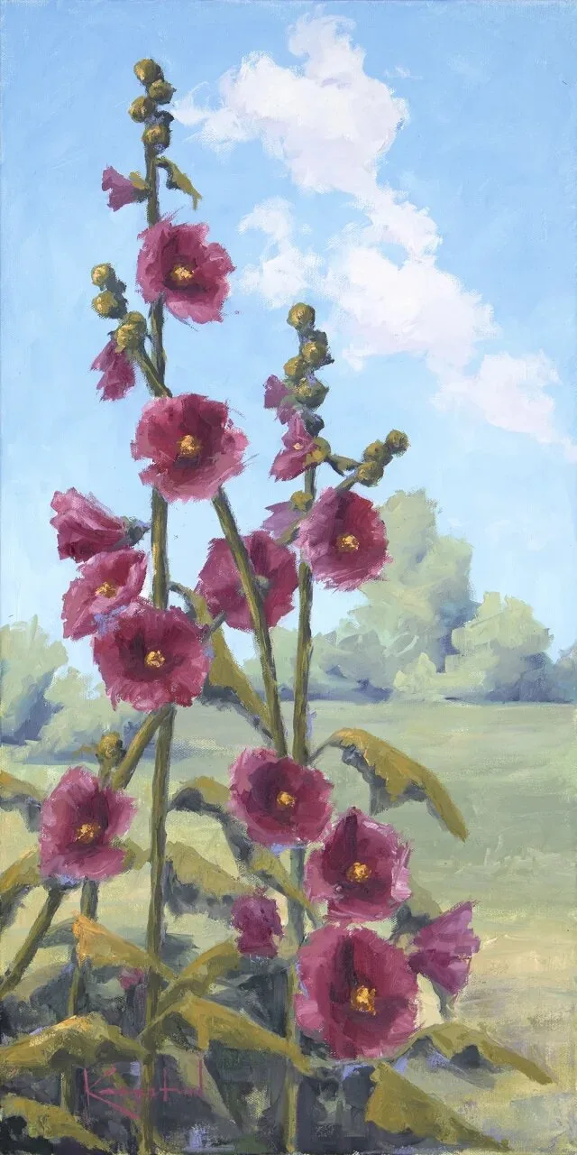 Tall pink hollyhock stalks against blue summer sky with distant trees and meadow