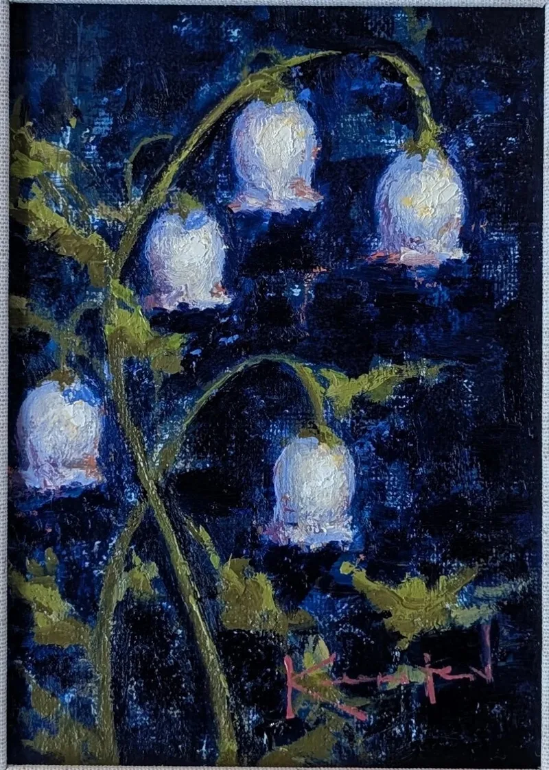 White bell-shaped lily of the valley flowers glowing against dark blue background