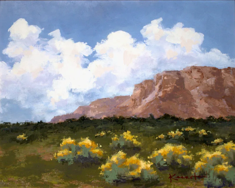 desert landscape with red sandstone bluffs yellow rabbitbrush and white clouds