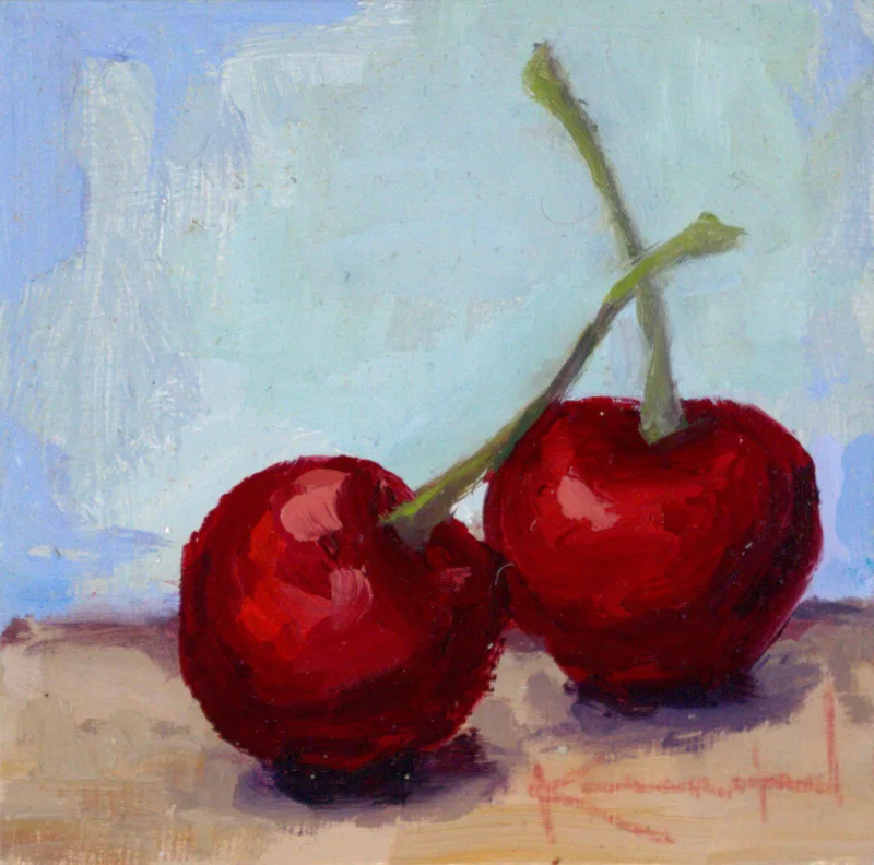 Pair of dark red cherries with green stems on table against blue background