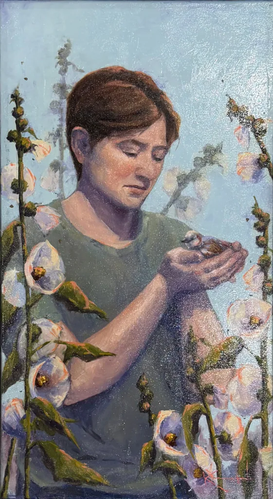 Young person in a green shirt gently cradling a fledgling bird, surrounded by white hollyhocks.