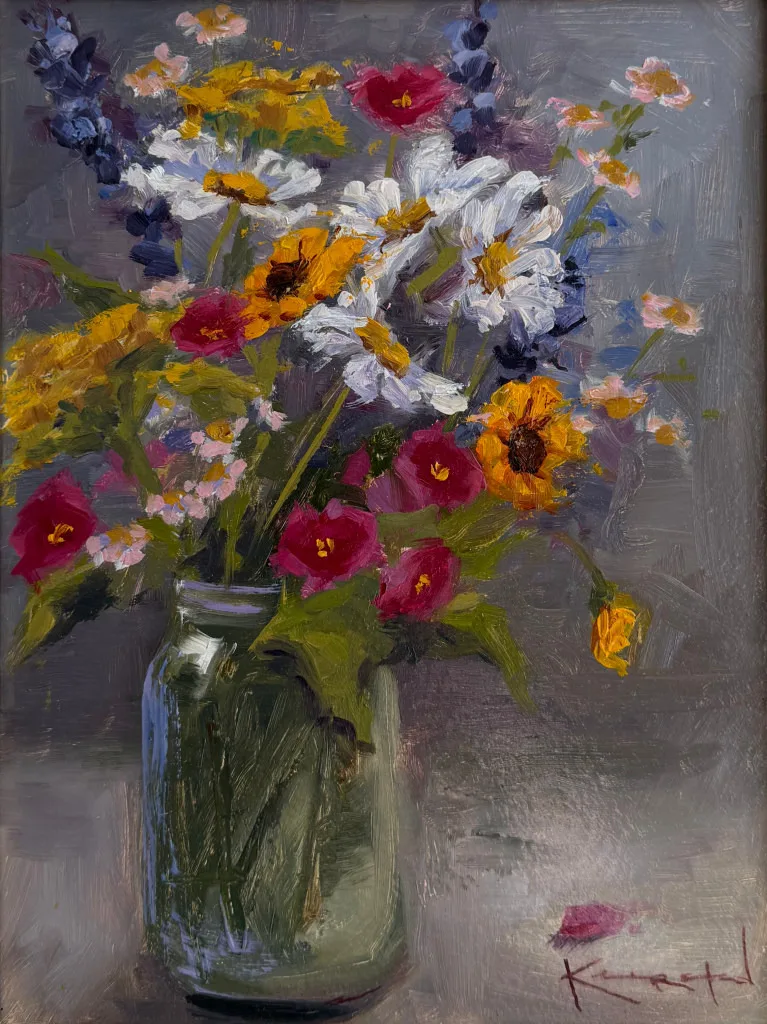Bouquet of daisies and mixed wildflowers in a glass jar.
